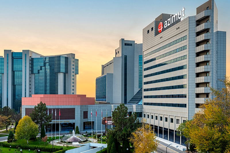 AZIMUT Grand Hotel Tashkent at sunset, seen across its gardens and fountain