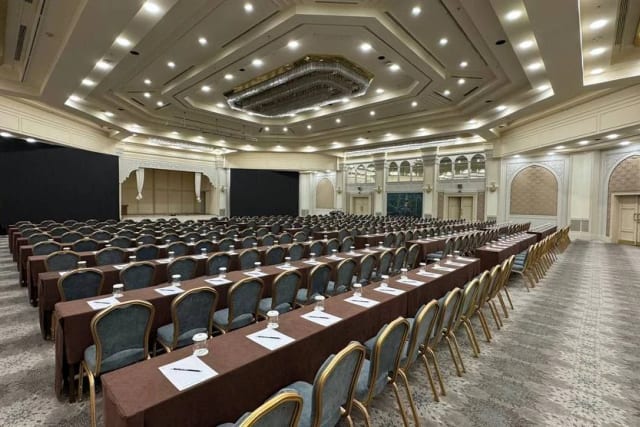 A large conference hall at AZIMUT Grand Hotel Tashkent, set with rows of tables