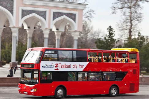 Red Tashkent City Tour double-decker sightseeing bus on a street in Tashkent