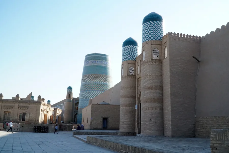Turquoise Kalta Minor and the walls of the Kukhna Ark fortress in Khiva
